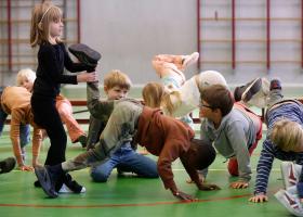 Workshop in een gymlokaal met kinderen die actief meedoen