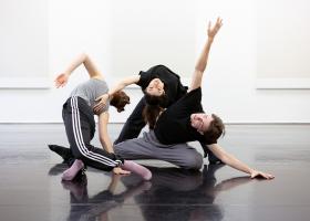 Drie dansers in verschillende posities in een dansstudio