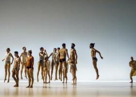 Foto uit de voorstelling Henry van Itamar Serussi met dansers die in een groep, op de plaats afzonderlijk van elkaar springen