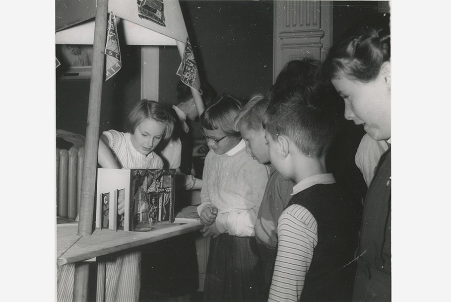 Kinderen bij het jubileumboek met voorstellingsmaquette (fotograaf onbekend)